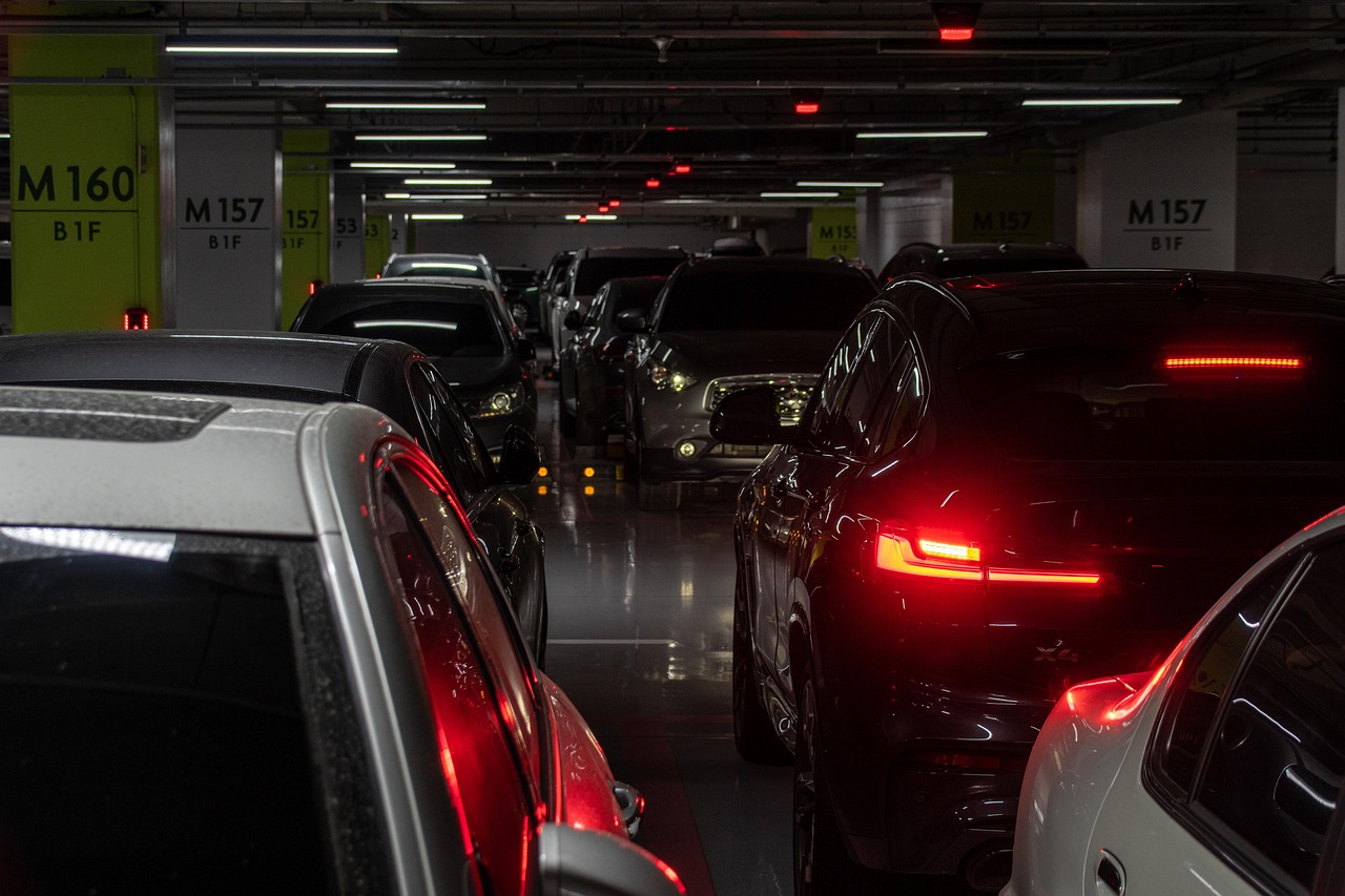Samochody stojące w rzędzie w ciemnym wielopoziomowym parkingu podziemnym – parking przy lotnisku chopina