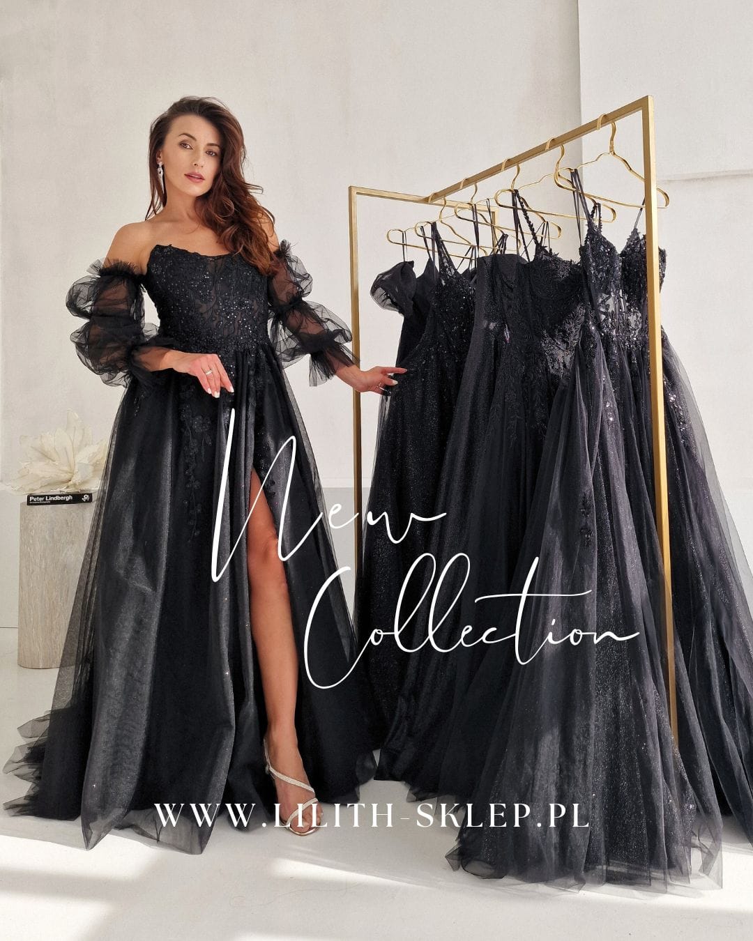 modelka w czarnej sukni obok złotego wieszaka z kreacjami wieczorowymi